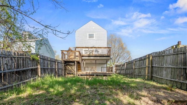 back of property with a fenced backyard and a deck