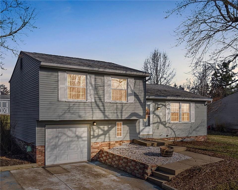 tri-level home featuring an attached garage and driveway