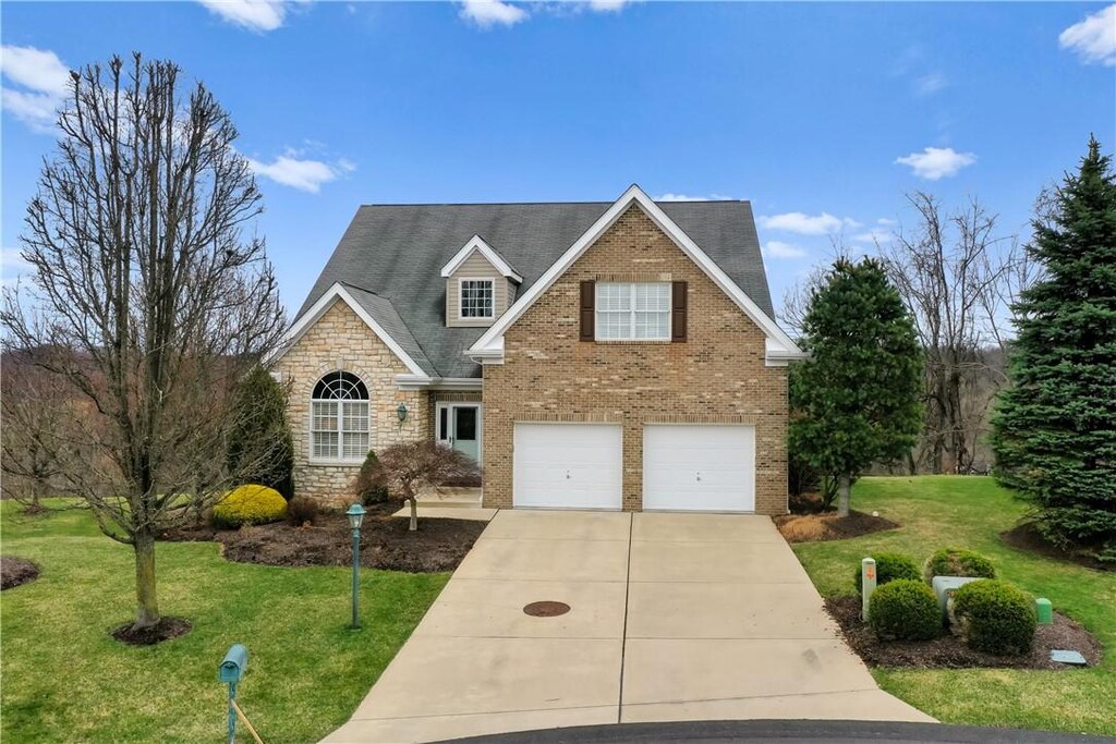 115 Windover Ct, North Strabane, PA 15317 - traditional-style house with a garage, concrete driveway, a front lawn, and stone siding