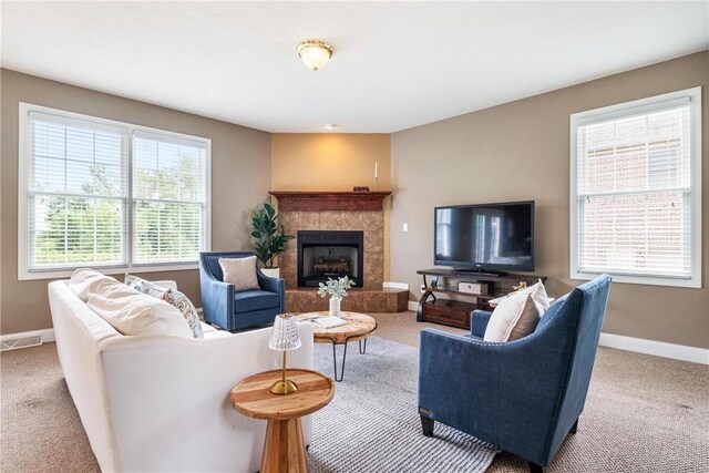 carpeted living area with a fireplace, baseboards, and visible vents