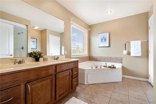 full bathroom with tile patterned flooring, double vanity, a garden tub, and a sink