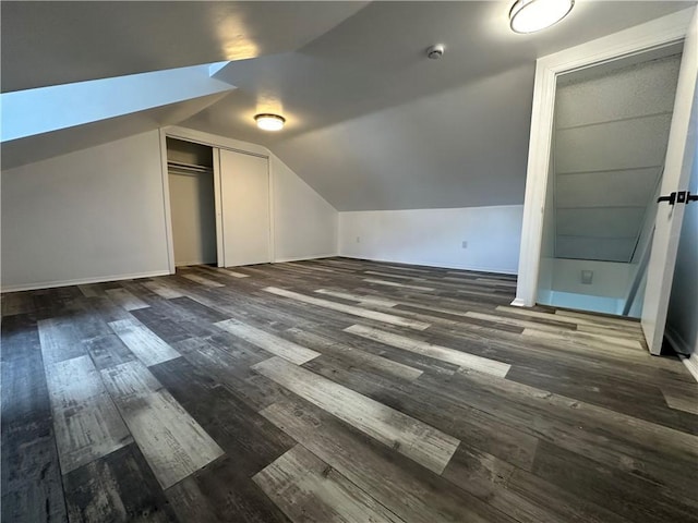 bonus room with baseboards, lofted ceiling, and wood finished floors