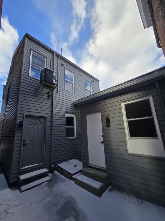 rear view of property featuring entry steps and central air condition unit