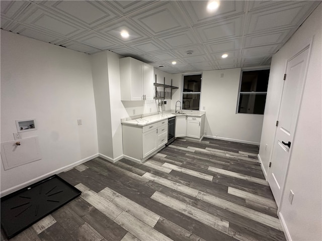 kitchen with light countertops, baseboards, white cabinets, dishwashing machine, and recessed lighting