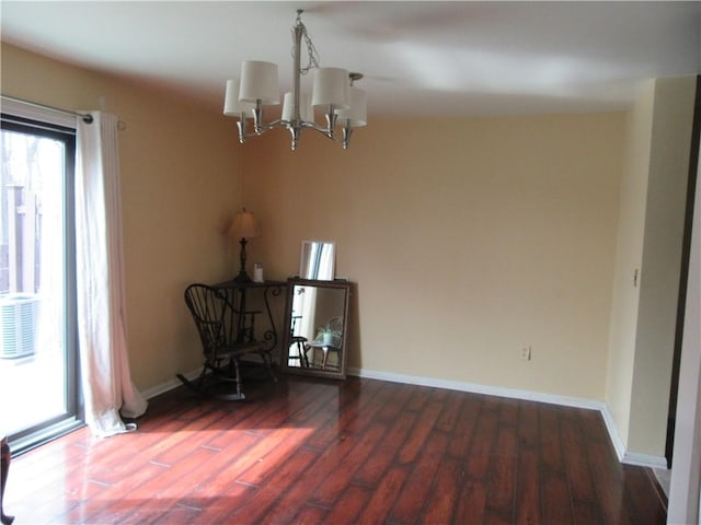 interior space featuring a notable chandelier, baseboards, and wood finished floors