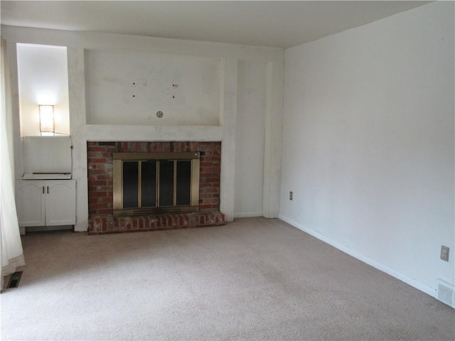 unfurnished living room featuring visible vents, a fireplace, baseboards, and carpet