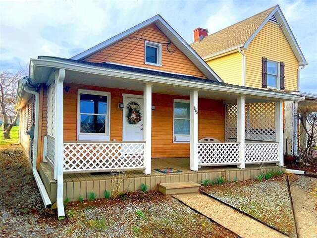 view of front of property featuring a porch and a chimney