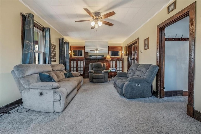 living area with carpet, a ceiling fan, and ornamental molding