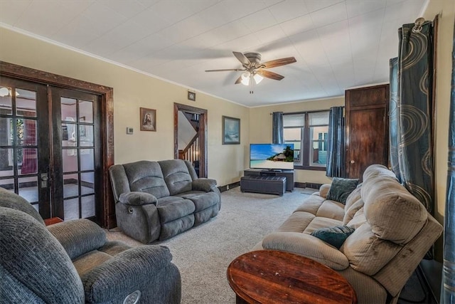 living area with carpet flooring, french doors, ceiling fan, ornamental molding, and stairway