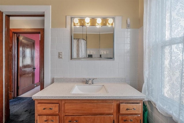 bathroom with tile walls, vanity, and healthy amount of natural light