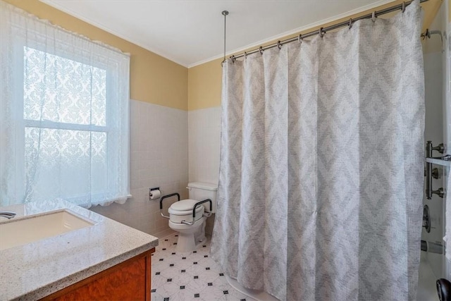 bathroom with tile walls, toilet, curtained shower, vanity, and a wainscoted wall