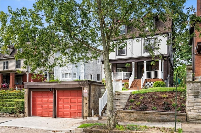 view of front of property with a porch, a garage, stairs, and concrete driveway