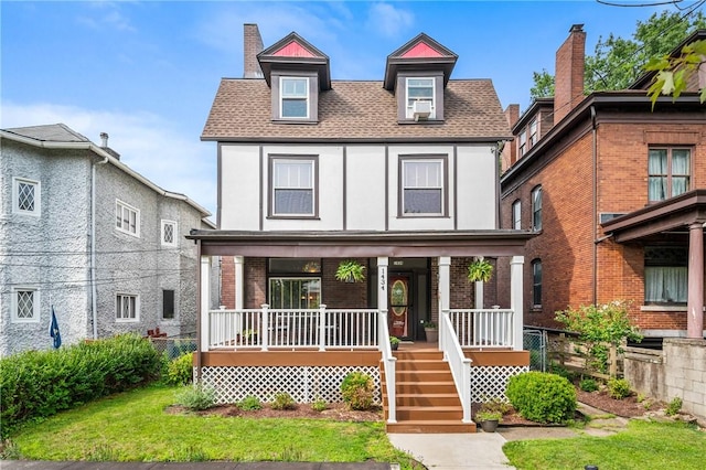 view of front of house with a porch, a shingled roof, stucco siding, and brick siding