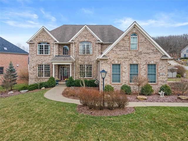 view of front of property with brick siding and a front lawn