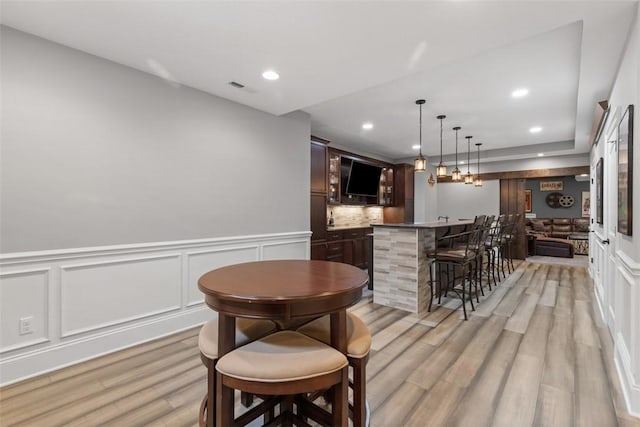 bar with visible vents, tasteful backsplash, recessed lighting, light wood finished floors, and indoor wet bar