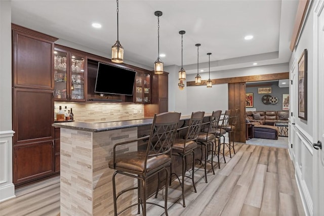 bar with backsplash, pendant lighting, recessed lighting, wet bar, and light wood-style floors