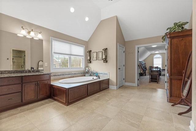 bathroom with plenty of natural light, a garden tub, and vaulted ceiling