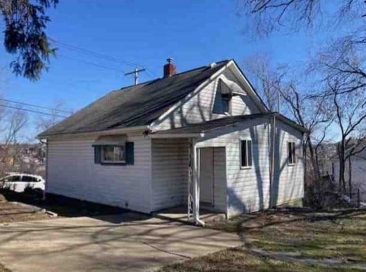 back of house featuring a chimney