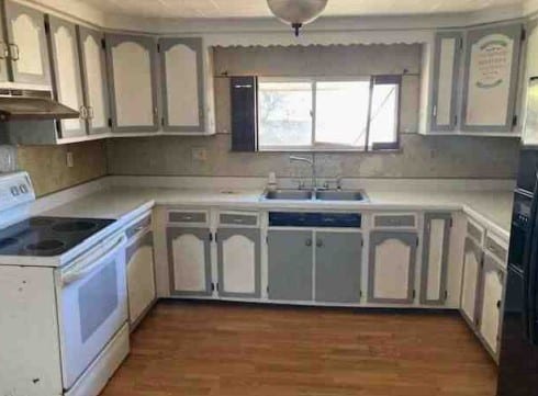 kitchen featuring under cabinet range hood, dark wood finished floors, light countertops, white electric range oven, and a sink