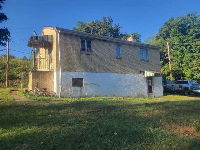 view of side of home with a lawn and a chimney