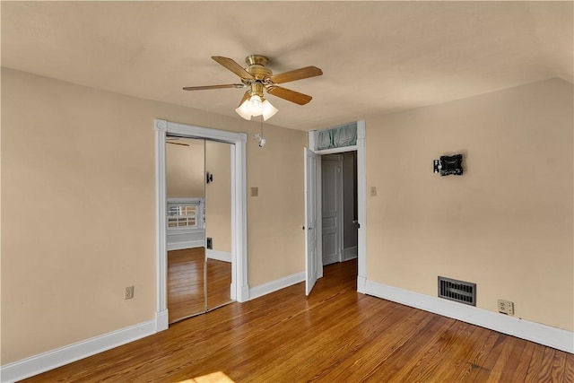 empty room featuring visible vents, baseboards, a ceiling fan, and wood finished floors
