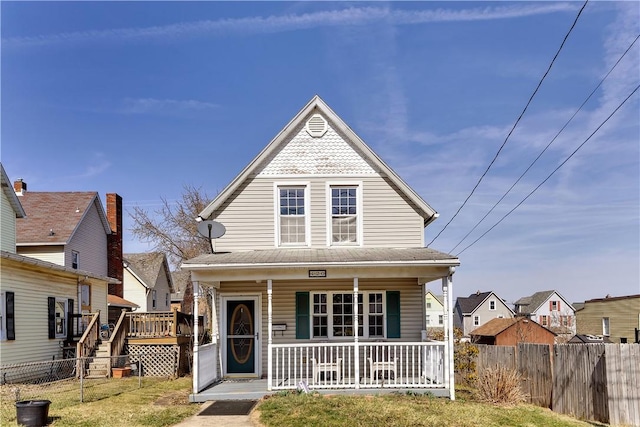 view of front facade featuring a porch and fence