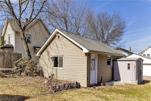 exterior space featuring an outbuilding, fence, a yard, a storage unit, and a garage