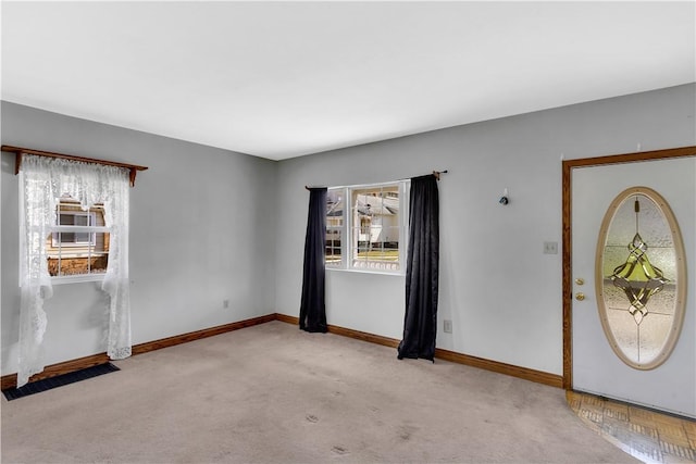carpeted entrance foyer featuring baseboards