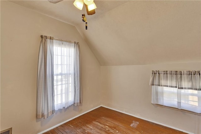 bonus room featuring visible vents, baseboards, vaulted ceiling, a ceiling fan, and wood-type flooring