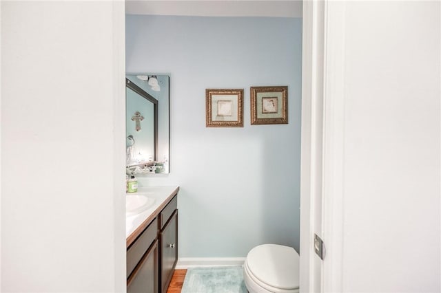 bathroom featuring vanity, toilet, and baseboards
