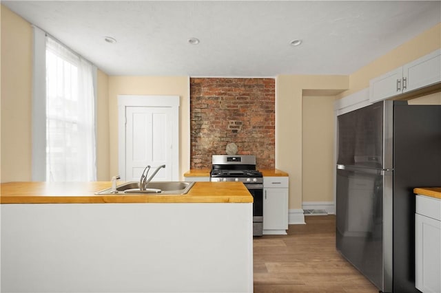 157-159 Grant Ave, Verona, PA 15147 - kitchen featuring light wood-style flooring, a sink, appliances with stainless steel finishes, white cabinetry, and butcher block counters