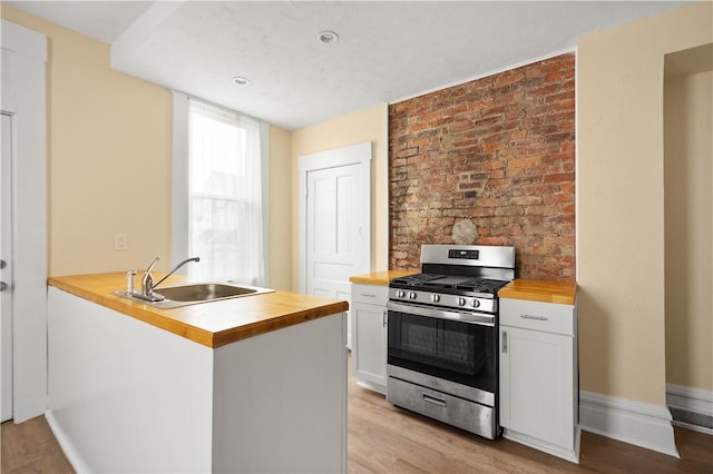 157-159 Grant Ave, Verona, PA 15147 - kitchen with light wood-style flooring, a sink, butcher block countertops, white cabinetry, and stainless steel gas stove