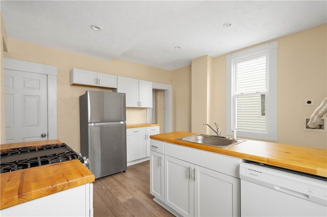 157-159 Grant Ave, Verona, PA 15147 - kitchen featuring white dishwasher, freestanding refrigerator, a sink, white cabinets, and wood counters