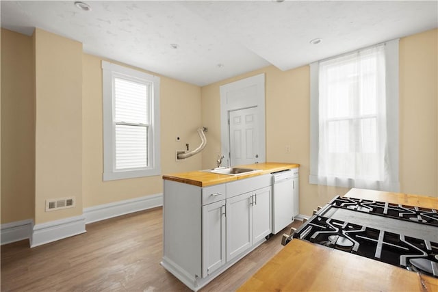 157-159 Grant Ave, Verona, PA 15147 - kitchen featuring visible vents, light wood-style floors, white dishwasher, wood counters, and a sink