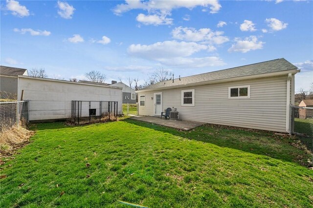 rear view of house featuring a patio, a lawn, and a fenced backyard