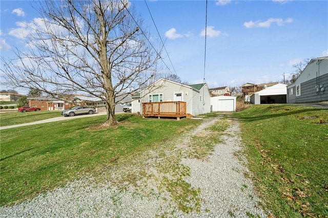 view of side of property featuring a yard, driveway, and a wooden deck