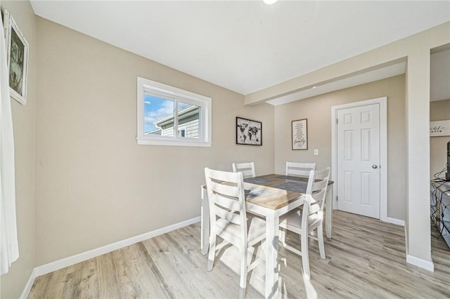 dining area featuring baseboards and light wood-style flooring