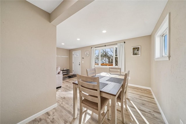 dining space with recessed lighting, baseboards, light wood-style floors, and a textured wall