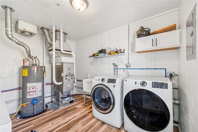laundry area with water heater, electric panel, light wood-style flooring, cabinet space, and separate washer and dryer