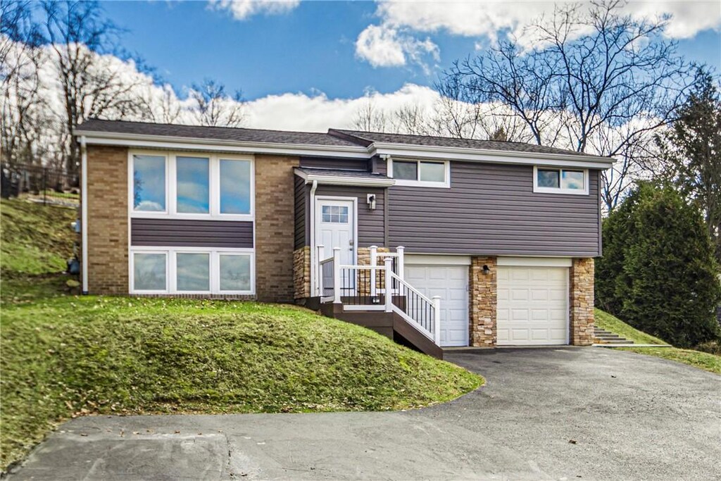 247 W Ingomar Rd, Mccandless, PA 15237 - split foyer home with aphalt driveway, brick siding, a garage, and stone siding