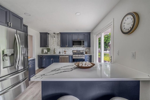 1693 Emery Dr, Mccandless, PA 15101 - kitchen with appliances with stainless steel finishes, a sink, light wood finished floors, backsplash, and blue cabinetry