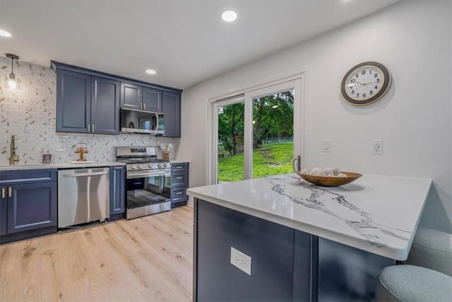 1693 Emery Dr, Mccandless, PA 15101 - kitchen with stainless steel appliances, blue cabinetry, decorative backsplash, light wood-style floors, and a sink
