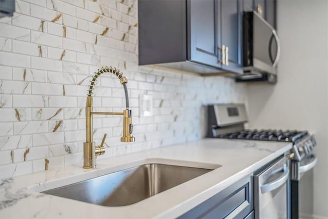 1693 Emery Dr, Mccandless, PA 15101 - kitchen featuring appliances with stainless steel finishes, a sink, decorative backsplash, blue cabinets, and light stone counters