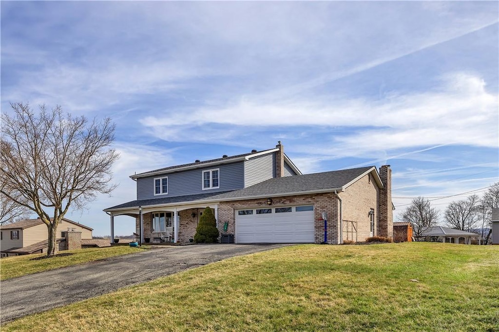 115 Virginia Ave, Vandergrift Wml, PA 15690 - traditional-style home with an attached garage, a chimney, a front lawn, aphalt driveway, and brick siding