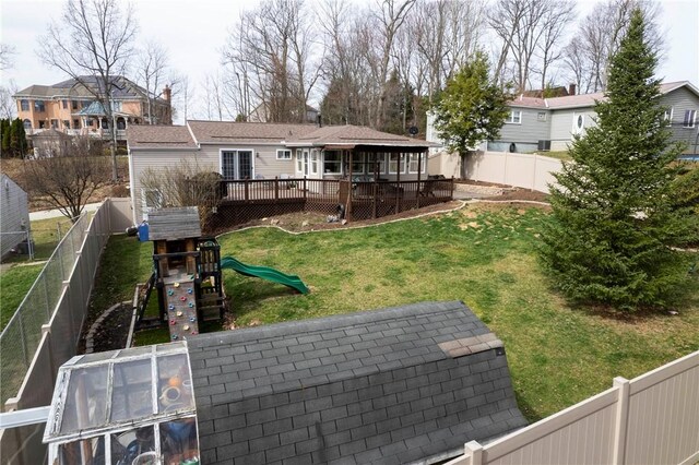 view of yard with a deck, a fenced backyard, and a playground