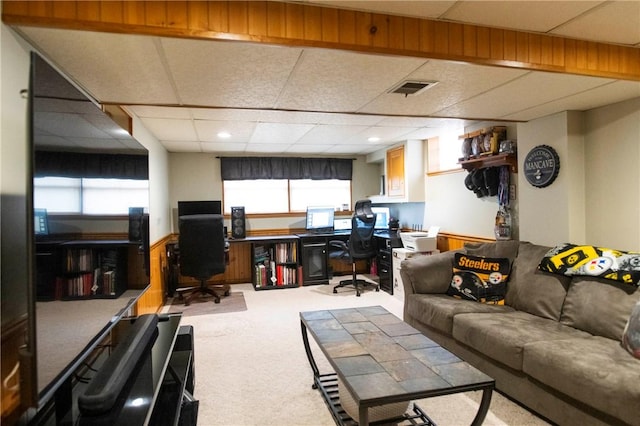 carpeted living area with visible vents and a drop ceiling