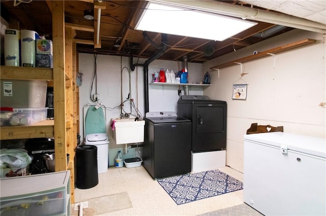 clothes washing area featuring washer and dryer, laundry area, tile patterned floors, and a sink