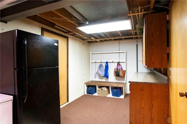 basement featuring carpet flooring and freestanding refrigerator
