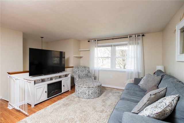 living area with light wood-type flooring and baseboards