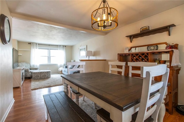 dining area featuring baseboards, an inviting chandelier, and wood finished floors